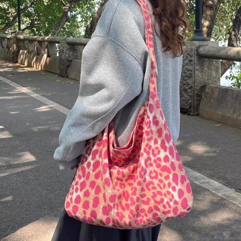 Eine lässige Pendler-Tragetasche und eine modische Umhängetasche zum Tragen über einer Schulter rosa